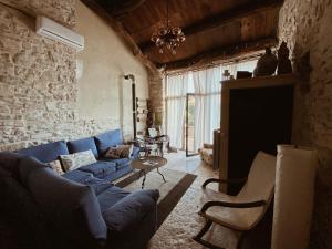 sala de estar con sofá azul y pared de piedra en Cal Pubillet, en el Mas de Bon Dia