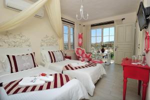 a room with two beds and a table and chairs at Alaçatı Sultan Konak Butik Otel ℳℛ Luxury Concept in Alacati