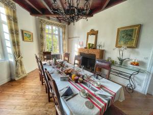 une salle à manger avec une grande table, des chaises et un lustre dans l'établissement Domaine Abartiague, à Ossès