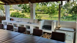 a outdoor kitchen with a counter and chairs and a table at Villa Prespa in Dolno Dupeni