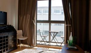 a living room with a large window with a balcony at City Center Luxury Apartment in Reykjavík