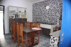 a kitchen with a dining room table and chairs at Pousada Flor de Aurora Bertioga in Bertioga