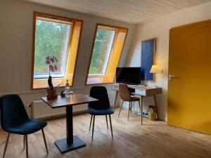 Cette chambre dispose d'une table, de chaises et d'un bureau. dans l'établissement Villa BlauwHemel Diever, à Diever