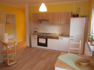 a kitchen with yellow walls and white appliances at Schwalbennest - 93355 in Marlow