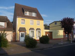 una casa amarilla con techo marrón en una calle en Schwalbennest - 93355, en Marlow