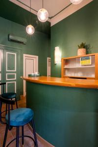 um bar com dois bancos numa sala com paredes verdes em Domus Pinciana em Roma