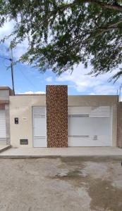 una casa con dos puertas de garaje y un árbol en Casa do Lamarques en Piranhas