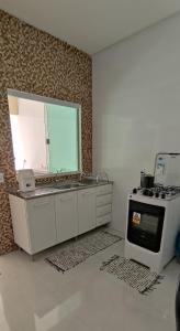 uma cozinha com um fogão, um lavatório e um forno em Casa do Lamarques em Piranhas