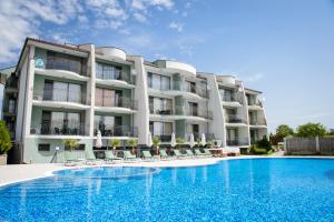 a hotel with a swimming pool in front of a building at Gardenia Vacation Settlement in Sozopol