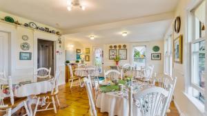 a dining room with white tables and chairs at Bayview Pines Country Inn B&B in Mahone Bay