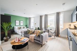 uma sala de estar com um sofá e uma cama em No. 2 Queensberry Place by Stayo em Londres