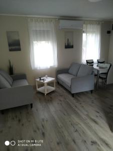 salon z 2 kanapami i stołem w obiekcie Süni apartman w mieście Ordacsehi