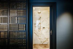 una puerta que conduce a una habitación con libros en la pared en Boutique Hotel The Noblemen, en Ámsterdam