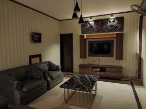 a living room with a couch and a tv at Holiday home On The rocks in Murree