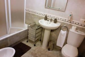 a bathroom with a sink and a toilet and a tub at Piso Vilavella in Redondela