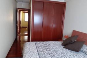 a bedroom with a bed and a wooden wall at Piso Vilavella in Redondela