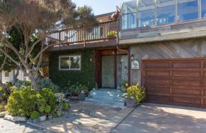 una casa con una puerta de madera y un árbol en Opal Cliff Beach House, en Santa Cruz