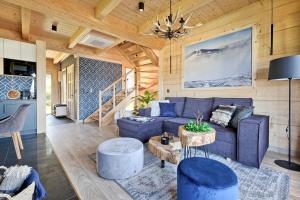 a living room with a blue couch and a table at Osada Bachledzki Wierch Odkryj Zakopane in Zakopane