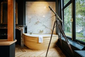 a large wooden tub in a bathroom with a telescope at Boutique Hotel The Noblemen in Amsterdam
