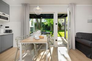 - une cuisine et une salle à manger avec une table et des chaises dans l'établissement Domki Villa Hoff Resort, à Trzęsacz