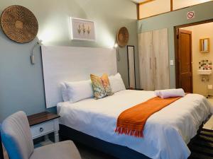 a hotel room with a bed and a chair at Bokamoso Views in Rustenburg +52 photos