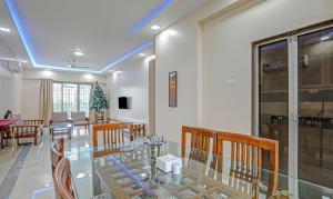 a dining room with a glass table and chairs at Treebo Trend Welcome Apartments in Mumbai