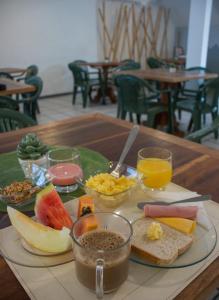 a wooden table with a plate of food on it at Joaquina Beach Hotel in Florianópolis