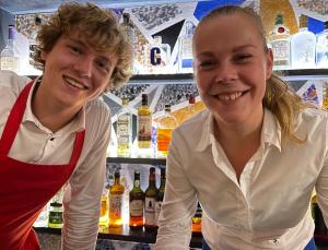 two people standing in a bar with bottles of wine at Villa BlauwHemel Diever in Diever