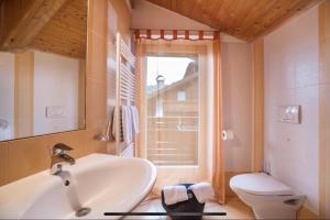 a bathroom with a sink and a toilet and a window at Villa Anita San Vigilio di Marebbe in San Vigilio Di Marebbe +61 photos