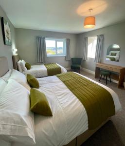 a hotel room with two beds and a desk at Garth- Stunning Scenic semi-rural Cottage with Games room in Conwy