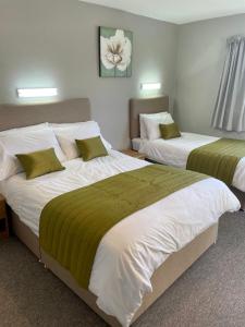 - 2 lits dans une chambre d'hôtel avec des tons verts et blancs dans l'établissement Garth- Stunning Scenic semi-rural Cottage with Games room, à Conwy
