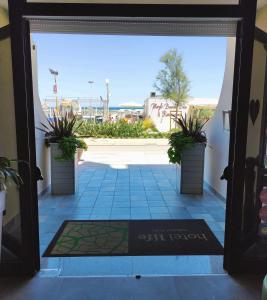 an open door with a view of a courtyard at Hotel Life in Rimini