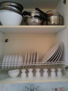 a shelf with plates and other dishes in a kitchen at Makenzy 12 in Larnaka