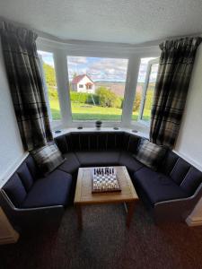 a living room with a blue couch and a table at Garth- Stunning Scenic semi-rural Cottage with Games room in Conwy
