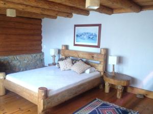 a bedroom with a bed in a room with wooden ceilings at Log Cabin - Monte Verde in Camanducaia