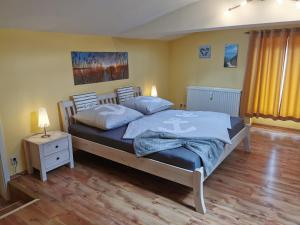 a bedroom with a bed with blue sheets and a night stand at Ferienwohnung Alte Feuerwehr in Ueckermünde
