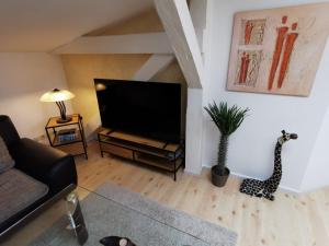 a living room with a television and a giraffe statue at Ferienwohnung Alte Feuerwehr in Ueckermünde