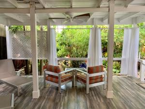 un porche con 2 sillas y una mesa en Douglas House, en Key West