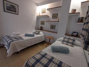 a bedroom with two beds and a table in it at Casa Es Mestral blue in Port de Pollensa