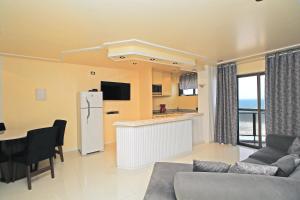 ein Wohnzimmer mit einem Kühlschrank und einer Küche in der Unterkunft Rio Spot Varanda da Barra U043 in Rio de Janeiro