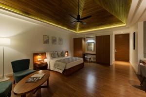 um quarto de hotel com uma cama e uma mesa em Aprota Villas Arugambay em Arugam Bay