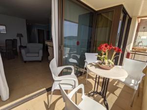 a balcony with a table and white chairs at Casa Es Mestral blue in Port de Pollensa