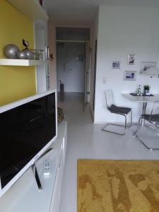 ein Wohnzimmer mit einem Flachbild-TV und einem Stuhl in der Unterkunft Smucke Stuuv I in Glücksburg