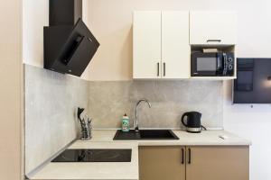 a kitchen with a sink and a microwave at Havana ApartHotel in Odesa