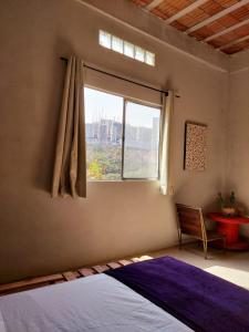 um quarto com uma cama e uma janela em Pousada Vila da Serra - Quarto do Amor em Nova Lima