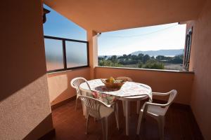 a balcony with a table and chairs and a window at Appartamenti Norsi in Capoliveri