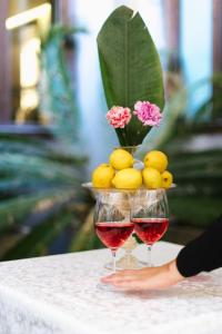 dos copas de vino tinto y un jarrón de limones en Hotel Do Pozzi, en Venecia