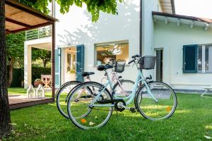two bikes parked in the grass in front of a house at Monti di Luna in Forte dei Marmi