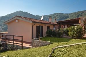 a house with mountains in the background at Appartamenti Norsi in Capoliveri