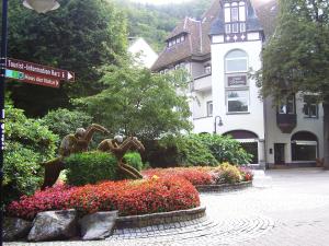 una statua di scimmie in un giardino fiorito di fronte a un edificio di Harzburger Ferienwohnung a Bad Harzburg